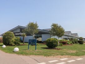A building with trees and a sign at The Boathouse in Pevensey
