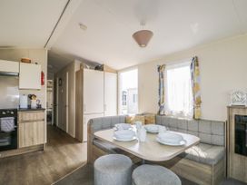 A dining room with a table set in a mobile home at Tower View Number 34 Pevensey Bay