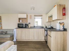A kitchen with appliances and furnishings at Tower View Number 34 Pevensey Bay