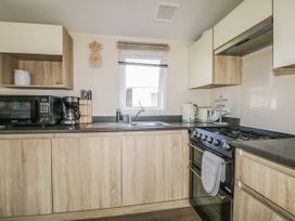A kitchen with appliances and cabinetry at Tower View Number 34 Pevensey Bay