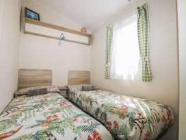 A bedroom with two beds and a shelf at Tower View Number 34 Pevensey Bay