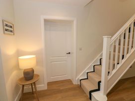 A hallway with a staircase and lamp at Hafan Y Gof Newcastle Emlyn