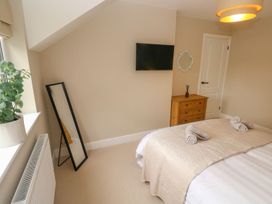 A bedroom with bed, television and mirror at Hafan Y Gof in Newcastle Emlyn