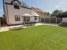 A garden with a patio, table and chairs at Hafan Y Gof in Newcastle Emlyn