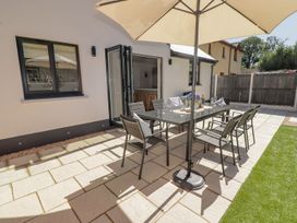 An outdoor dining area with a table and chairs at Hafan Y Gof Newcastle Emlyn