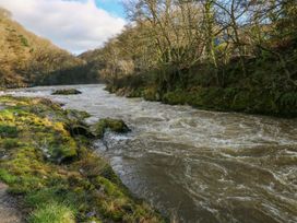 A river flowing past rocks and grass at Hafan Y Gof Newcastle Emlyn