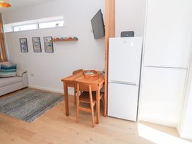 A living room with a table and chairs beside a fridge at Carn Brea in Redruth
