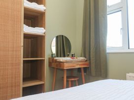 A bedroom with towels on shelves and a table with a mirror at Carn Brea in Redruth