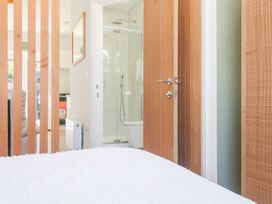 A bedroom with wooden door and shower area at Carn Brea in Redruth