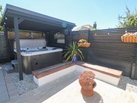 A garden with a hot tub and wooden seating areas at Carn Brea in Redruth