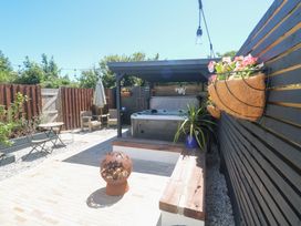 A garden with a hot tub and wooden seating at Carn Brea in Redruth