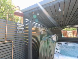 An outdoor area with a hot tub and wooden slat enclosure at Carn Brea in Redruth