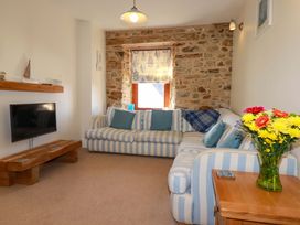 A living room with a striped sofa and television at 3 The Old Cornstore