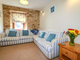A living room with a sofa and a vase of flowers at 3 The Old Cornstore