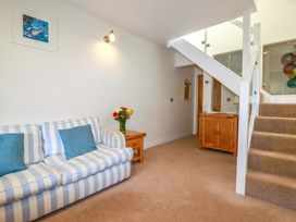 A living room with a sofa and flowers on a table at 3 The Old Cornstore