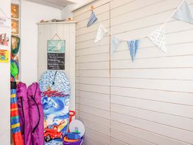 An entryway with a surfboard and fishing nets at 3 The Old Cornstore