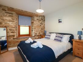 A bedroom with a bed and a mirror at 3 The Old Cornstore