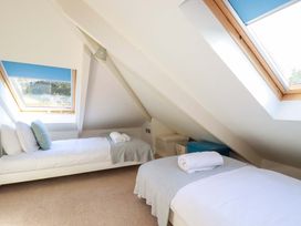 A bedroom with two single beds and windows at 3 The Old Cornstore