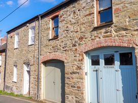 A stone building with windows and a blue door at 3 The Old Cornstore in St Agnes