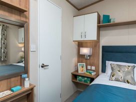 A bedroom with bed and mirror at Aquadrome Abode 3bed - Billing Aquadrome