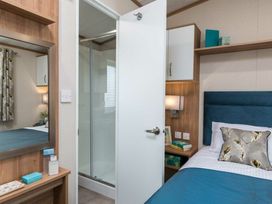 A bedroom with a bed and shower room at Aquadrome Abode 3bed - Billing Aquadrome