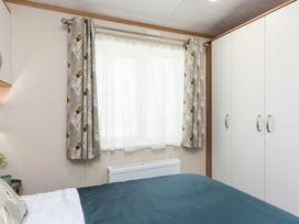 A bedroom with a bed and wardrobe at Aquadrome Abode 3bed - Billing Aquadrome