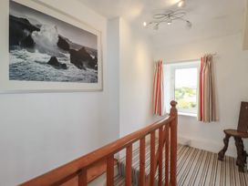 A staircase with a framed photo and a window at Trevean in Bude