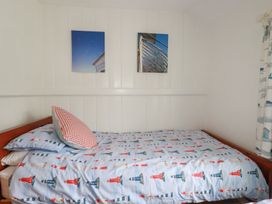 A bedroom with a bed, patterned bedding, and wall art at Trevean in Bude