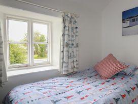 A bedroom with a bed next to a window at Trevean in Bude