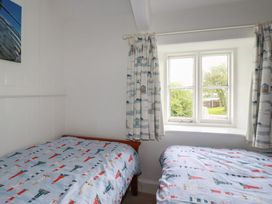 A bedroom with two beds and a window at Trevean in Bude
