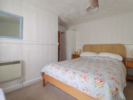 A bedroom with a bed and bedside tables at Trevean in Bude