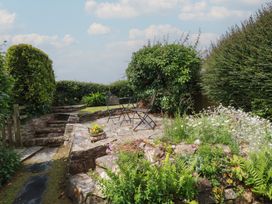 A garden with chairs and flowers at Trevean in Bude