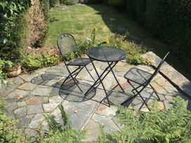 A garden area with a table and two chairs at Trevean in Crackington Haven
