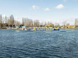 A lake with inflatable obstacles and cabins at Skylight Stargazer - Billing Aquadrome