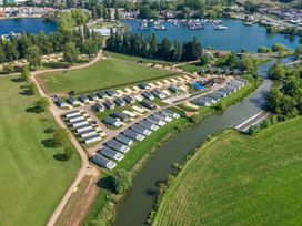 An outdoor area with caravans and a river at Skylight Stargazer - Billing Aquadrome