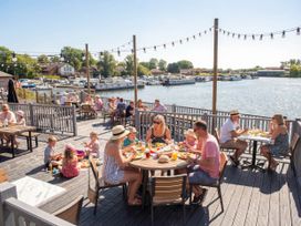 An outdoor dining area with people eating by the water at Skylight Stargazer - Billing Aquadrome
