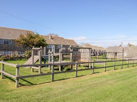 A playground with equipment and houses at Mallow Cottage in Langton Matravers