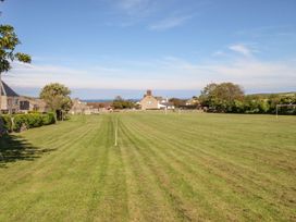 A grassy field with goalposts and homes in the background at Mallow Cottage in Langton Matravers