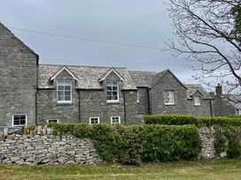 A stone house with windows and slate roof at Mallow Cottage in Langton Matravers