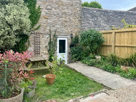 A garden with plants and a table at Mallow Cottage in Langton Matravers