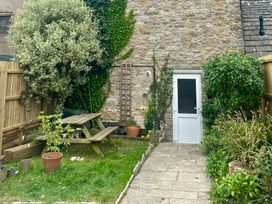 A garden with a picnic table and plants at Mallow Cottage in Langton Matravers