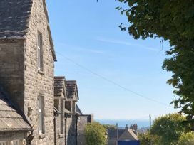 An outdoor view of stone buildings under a clear sky at Mallow Cottage in Langton Matravers