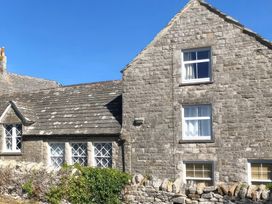 An exterior view of a stone cottage with windows at Mallow Cottage in Langton Matravers