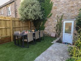 A garden with a dining table and chairs at Mallow Cottage in Langton Matravers