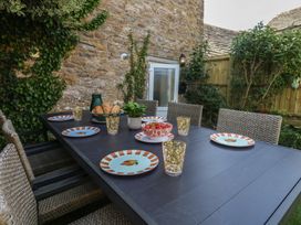 An outdoor dining area with a table set at Mallow Cottage in Langton Matravers