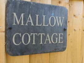 A sign reading Mallow Cottage on a wooden wall at Mallow Cottage Langton Matravers