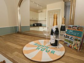 A kitchen countertop with champagne and glasses at Mallow Cottage in Langton Matravers