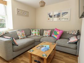 A living room with a grey sofa and coffee table at Mallow Cottage in Langton Matravers