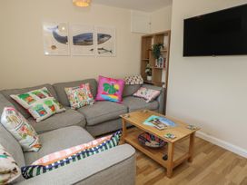 A living room with a grey sofa and a coffee table at Mallow Cottage in Langton Matravers