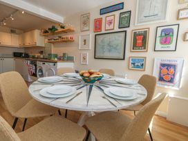 A dining room with a round table and chairs at Mallow Cottage in Langton Matravers